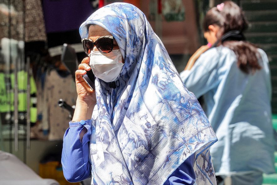Une femme parle au téléphone et marche dans une rue de Téhéran, le 10 septembre 2023